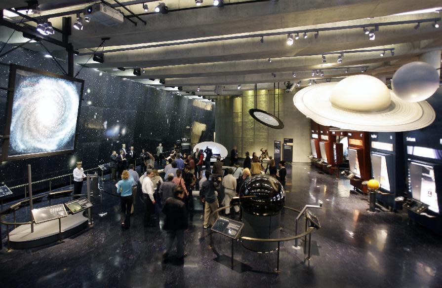 FILE - In this Oct. 3, 2006 file photo, people explore the interior of the expanded Griffith Observatory on Mount Hollywood in Los Angeles. Griffith Park bills itself as the largest urban wilderness in the United States. While the zoo and some of the park's other attractions charge admission, the world-famous Griffith Observatory does not. Nighttime visitors are free to check out the moon and stars through its powerful telescopes, while those arriving during the day can safely gaze at the sun. Or they can just walk outside to take in some of the city's best views of the iconic Hollywood Sign. (AP Photo/Damian Dovarganes, File)