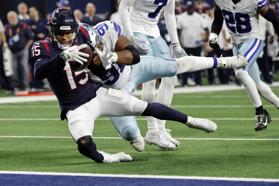 Houston Texans wide receiver Chris Moore (15) is stopped short of the goal line by Dallas Cowboys defensive end Carlos Watkins (91) during the second half of an NFL football game, Sunday, Dec. 11, 2022, in Arlington, Texas. (AP Photo/Michael Ainsworth)