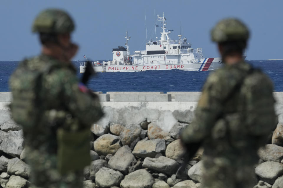 FILE - Philippine troops watch a Philippine coast guard ship as they secure an area at the Philippine-occupied Thitu island, locally called Pag-asa island, on Dec. 1, 2023, at the disputed South China Sea. China has been at odds with many other countries in the Asia-Pacific for years over its sweeping maritime claims, including almost all of the South China Sea, a strategic and resource-rich waterway around which Beijing has drawn a 10-dash-line on official maps to delineate what it says it its territory. (AP Photo/Aaron Favila, File)