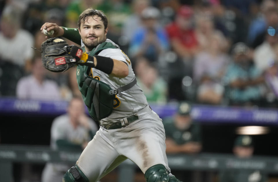 Oakland Athletics catcher Shea Langeliers throws to first base to put out Colorado Rockies' Randal Grichuk during the seventh inning of a baseball game Friday, July 28, 2023, in Denver. (AP Photo/David Zalubowski)