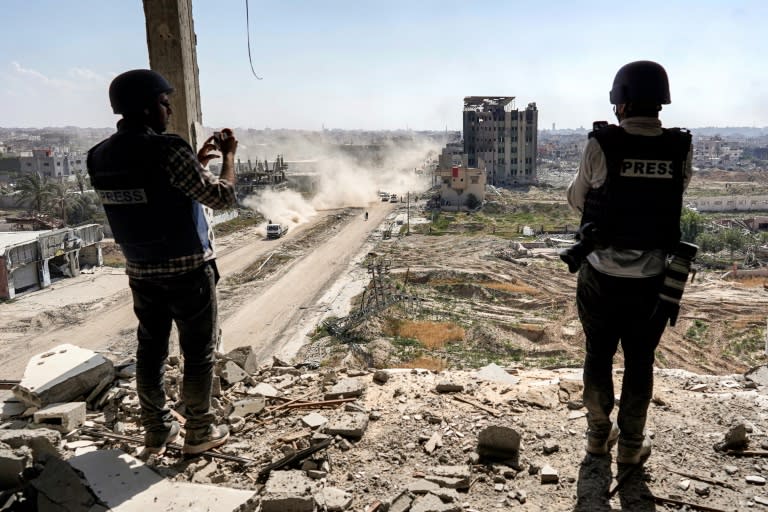 Journalists film from atop a damaged building facing the ravaged Al-Salam hospital in Khan Yunis in Gaza in April 2024 (-)