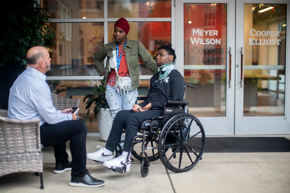 Mary S. Washington stands by her son, 15-year-old Damarion Allen, who is in a wheelchair after being left paralyzed from the chest down in the aftermath of a May 7 fight inside the Franklin County Juvenile Intervention Center. Washington and Allen are talking to one of their attorneys, Rex Elliott, a partner in the Columbus law firm, Cooper Elliott.