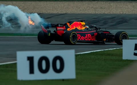 A trail of smoke and flames is seen from the car of Red Bull's Australian driver Daniel Ricciardo during a practice session for the Formula One Chinese Grand Prix - Credit: AFP