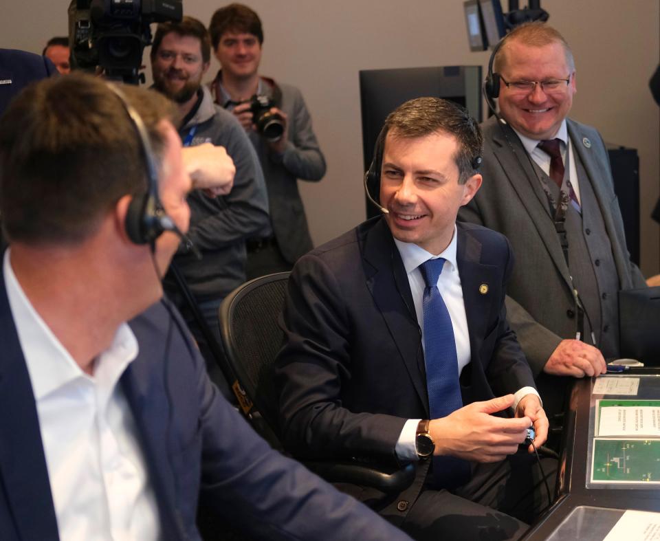 U.S. Transportation Secretary Pete Buttigieg, middle, laughs with Oklahoma Gov. Kevin Stitt, left, and Luther "Dewayne" Davis inside an air traffic controller simulator on Thursday.