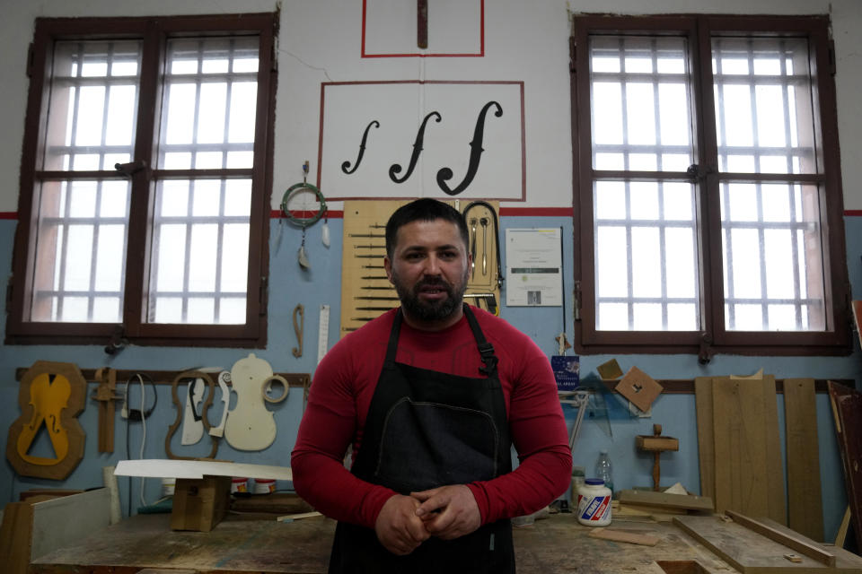 Milan's Opera maximum security prison inmate Nikolae (last name not available) talks with journalist during a interview with Associated Press in the prison's lab, near Milan, northern Italy, Friday, Feb. 9, 2024. Inmates at Opera used the wood of wrecked boats sailed by migrants across the Sicily Channel to craft the musical instruments that the 'Sea Orchestra' used during their debut at La Scala Opera House in Milan on Monday, Feb. 12, 2024. The violins, violas and cellos played by the Orchestra of the Sea in its debut performance Monday at Milan's famed Teatro all Scala carry with them tales of hardship. (AP Photo/Antonio Calanni)