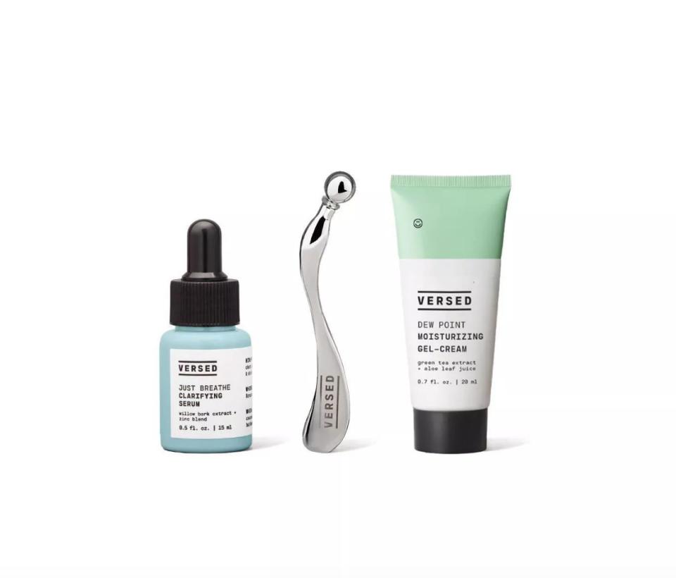 Blue bottle of serum, silver acupuncture tool, and green and white tube of moisturizer
