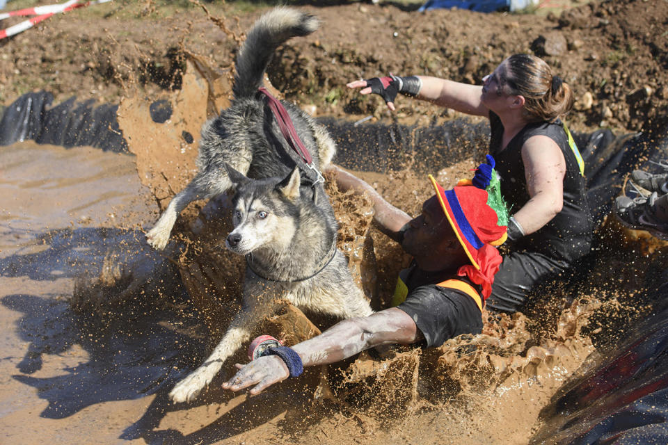 <p>Participants, one with a dog, take part in the 3rd extreme “La Barjot Run” running into the water in Biere, Switzerland, April 8, 2017. Around 1,500 participants have to run a 5 or 9 km track with mud, artificial obstacles and water. (Photo: Martial Trezzini/AP) </p>