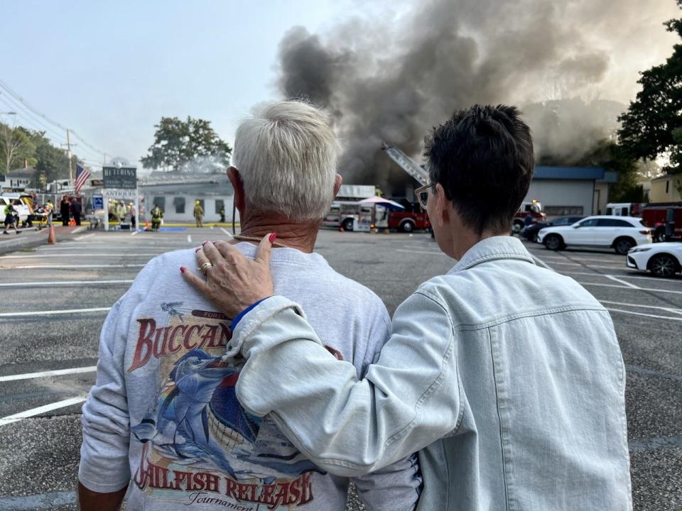 Tom and Betty Hutchins watch firefighters battle a fire in the Hutchins Antiques, Etc. building at 166 Main St. in Ogunquit, Maine, Saturday, Sept. 10, 2022.