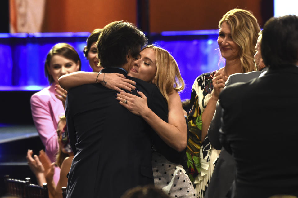 Noah Baumbach, from left, embraces Scarlett Johannson after winning the award for best screenplay at the 35th Film Independent Spirit Awards on Saturday, Feb. 8, 2020, in Santa Monica, Calif. (AP Photo/Chris Pizzello). Laura Dern looks on.