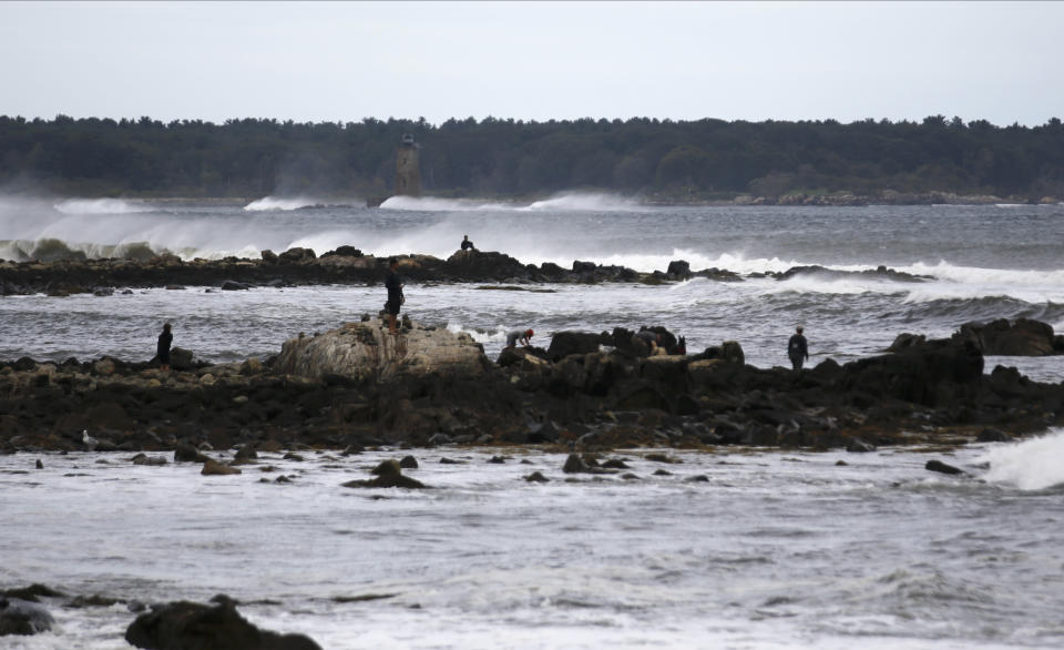People watch waves from Lee, Saturday, Sept. 16, 2023, in Rye, N.H. The storm is expected to make landfall Saturday in Canada at near hurricane strength and then move farther into the region. (AP Photo/Caleb Jones)