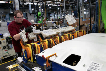 A General Motors assembly worker loads the HIC plastic caps at a Collaborative Robot adhesive station at Orion Assembly in Lake Orion, Michigan, U.S., March 19, 2018. REUTERS/Rebecca Cook/Files