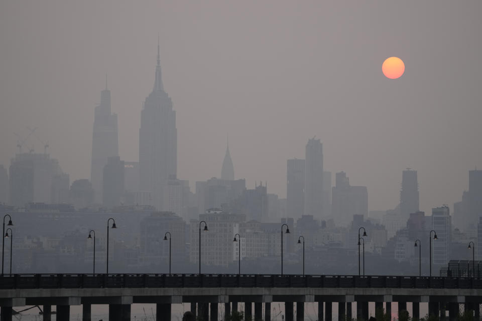 The sun rises over a hazy New York City skyline as seen from Jersey City, N.J., Wednesday, June 7, 2023. Intense Canadian wildfires are blanketing the northeastern U.S. in a dystopian haze, turning the air acrid, the sky yellowish gray and prompting warnings for vulnerable populations to stay inside. (AP Photo/Seth Wenig)