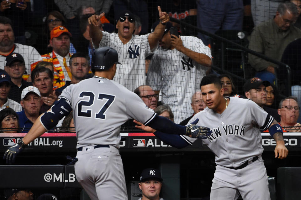 HOUSTON, TX - OCTOBER 12:  Giancarlo Stanton #27 of the New York Yankees is greeted by teammate Gleyber Torres #25 after hitting a solo home run in the sixth inning during Game 1 of the ALCS between the New York Yankees and the Houston Astros at Minute Maid Park on Saturday, October 12, 2019 in Houston, Texas. (Photo by Cooper Neill/MLB Photos via Getty Images)