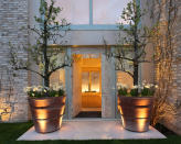 <p> Speak to your garden designer about lighting that will draw attention to the items on your porch, but in a soft, welcoming way. </p> <p> Here, lights on the ground beam upwards to illuminate the planters, the shrubs and the wall. Hiding the light source is imperative as it creates a feeling of ambience. </p>