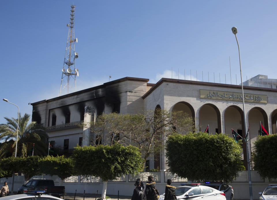 Fire damaged the foreign ministry building, after a deadly attack, in Tripoli, Libya, Tuesday, Dec, 25, 2018. Security officials said Tuesday that a suicide bomber targeted the entrance of Libya’s Foreign Ministry in Tripoli, killing several people, including a prominent militia leader. They said a second attacker was shot dead by guards before he could detonate his explosive vest. (AP Photo/Mohamed Ben Khalifa)