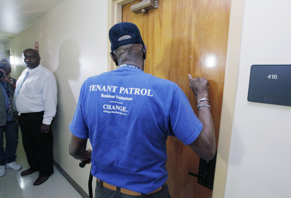 Richard Morgan, a tenant patrol volunteer makes a well-being check on a tenant at The Chicago Housing Authority's Apartamentos Las Americas Friday, July 6, 2012, in Chicago accompanied by CHA’s Director of Asset Manager Eric Garrett, left. The Chicago Housing Authority has conducted almost 44,000 well-being checks on its frail and elderly residents since Chicago’s heat wave began on Monday, July 2. Temperatures in the city are expected to be in the hundreds for a third straight day. (AP Photo/M. Spencer Green)