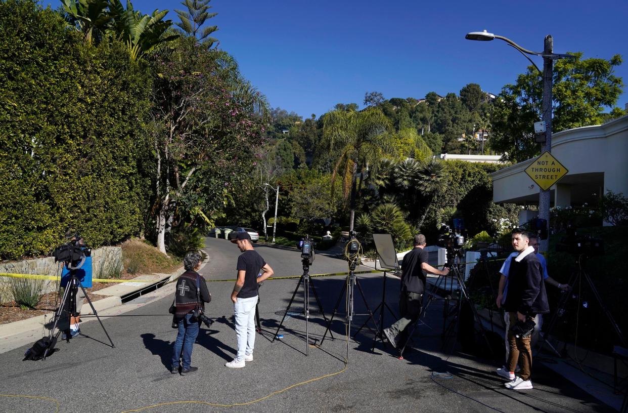 Media gather at the intersection of Maytor Place and Barrie Drive in the Trousdale Estates section of Beverly Hills, Calif., on Wednesday.