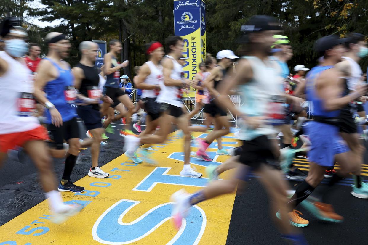 FILE - Runners cross the starting line of the 125th Boston Marathon, Monday, Oct. 11, 2021, in Hopkinton, Mass. 