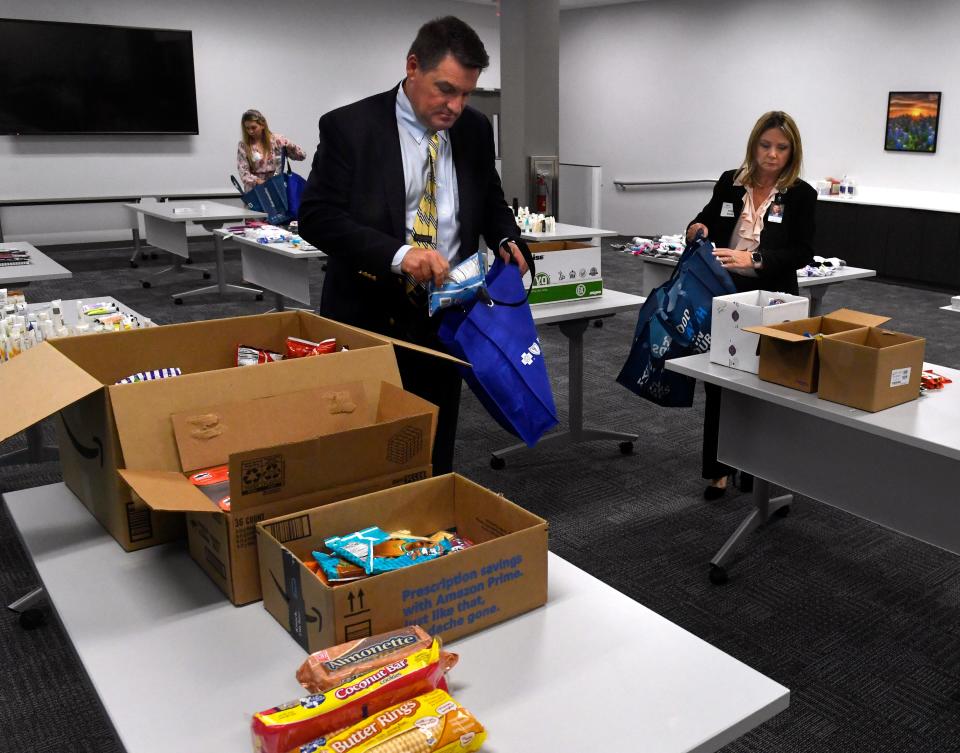 Jim Springfield, president of Blue Cross and Blue Shield of Texas (center), along with other workers in the Abilene office, packs gift bags for seniors at nursing homes May 17. The Abilene office of the insurance company frequently sets up tables like these in a conference room for employees to come take a break and help create the gift bags.