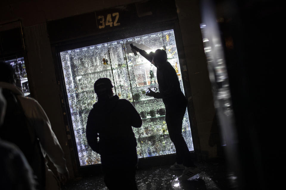 People break into a smoke shop on Monday, June 1, 2020, in New York. Protests were held throughout the city over the death of George Floyd, a black man in police custody in Minneapolis who died after being restrained by police officers on Memorial Day. (AP Photo/Wong Maye-E)