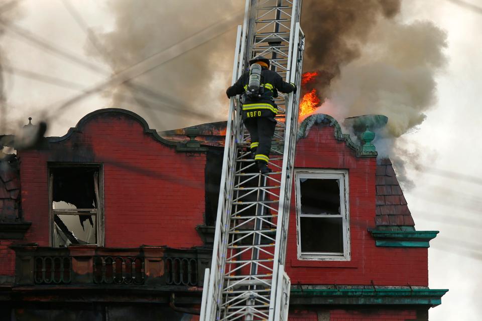 New Bedford firefighters battle a fire at 1301-1307 Acushnet Avenue in a rooming house Tuesday, March 28.