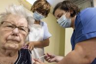 A woman gets a COVID-19 Pfizer booster shot in the "Im Lauesch" nursing home of Strasbourg, eastern France, Friday, Sept.24, 2021. France is recommending that people with pre-existing health problems and those over 65 receive a third shot six months after their second dose. (AP Photo/Jean-Francois Badias)