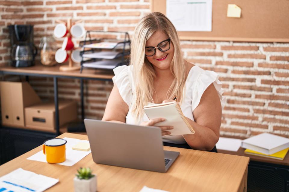 A woman sitting at a desk working on a laptop