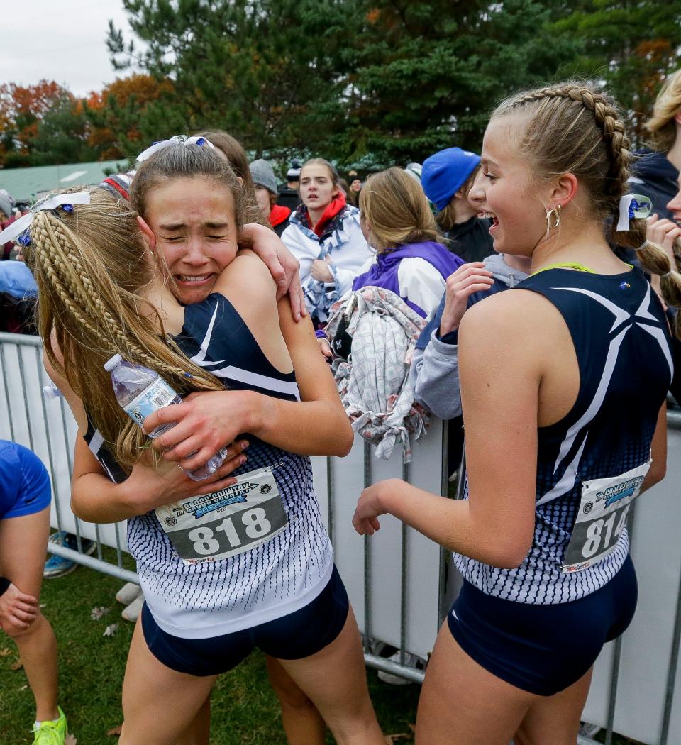 Xavier's Lilie Fouts embraces Elle Krull after finishing their race during the WIAA Division 2 state girls cross-country meet Saturday in Wisconsin Rapids.