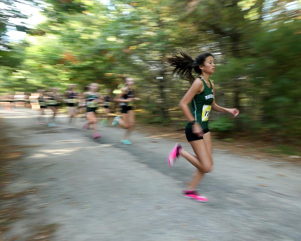 Eleanor Angeles-Whitfileld is a blur of motion at the start of her meet against Hingham at Marshfield High on Wednesday, Oct. 12, 2022. She would place first overall with a time of 18:34.64. Marshfield girls would win 19-39 while Marshfield boys won 19-44. 