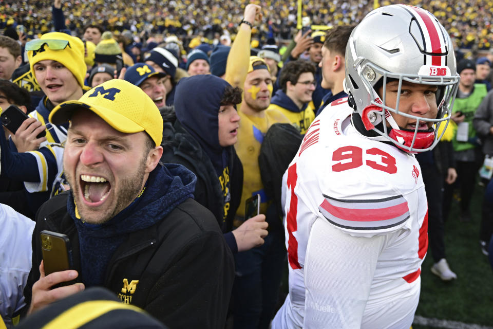 Ohio State defensive tackle Hero Kanu walks off as fans rush the field after Ohio State was defeated 30-24 by Michigan in an NCAA college football game, Saturday, Nov. 25, 2023, in Ann Arbor, Mich. (AP Photo/David Dermer)