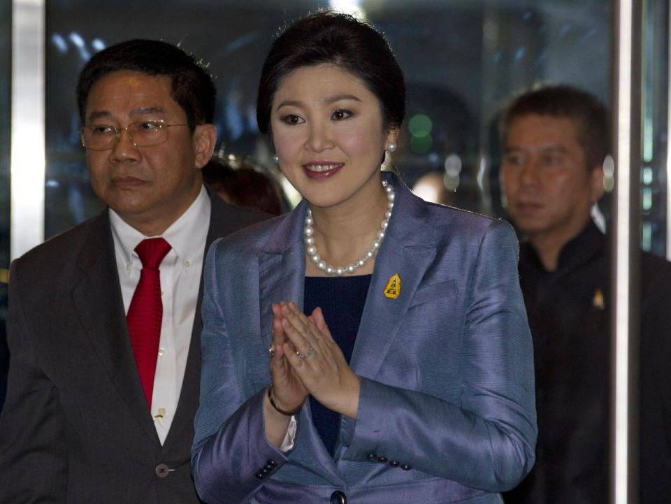 Thailand's Prime Minister Yingluck Shinawatra, center, arrives at the Constitutional Court in Bangkok, Thailand, Tuesday, May 6, 2014. Yingluck defended herself Tuesday against abuse of power allegations in a crucial court case that is one of several legal challenges which could remove her from office. She is accused of abusing her authority by transferring her National Security Council chief in 2011 to another position. (AP Photo/Sakchai Lalit)