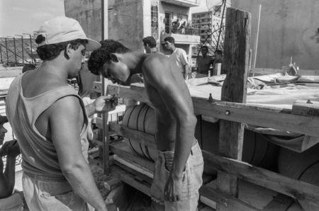 Would-be emigrants take a break while getting ready to lower their makeshift boat from a rooftop to a truck and launch it into the Straits of Florida towards the U.S., on the last day of the 1994 Cuban Exodus in Havana, September 13, 1994. REUTERS/Rolando Pujol Rodriguez