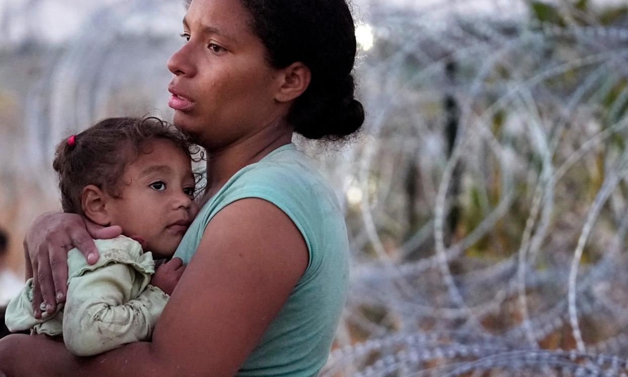 <span>A woman and her daughter at the US-Mexico border. Many migrants have found themselves stuck in Mexico.</span><span>Photograph: Eric Gay/AP</span>