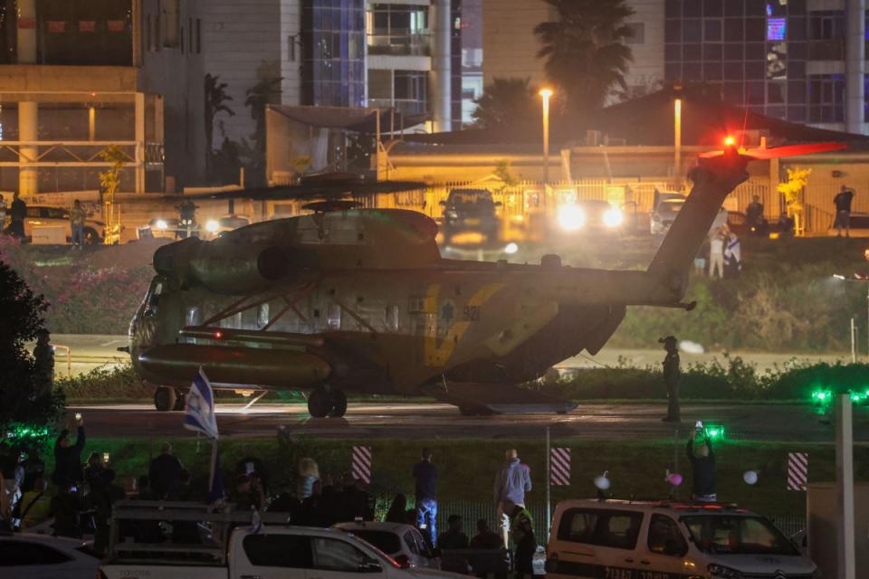 People look on as an Israeli helicopter with released hostages lands at Tel Aviv's Schneider medical centre on November 24 (AFP via Getty Images)