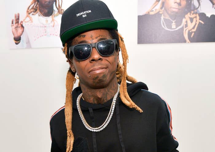 Wayne wears a black flat brim cap, sunglasses and a black sweatshirt