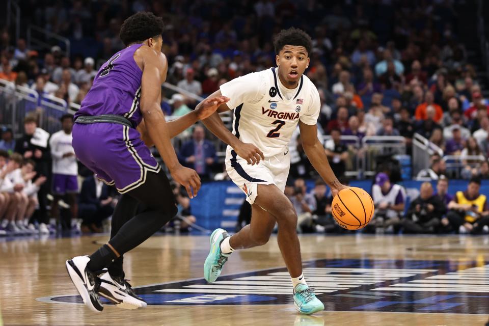 Mar 16, 2023; Orlando, FL, USA; Virginia Cavaliers guard Reece Beekman (2) dribbles the ball while defended by Furman Paladins guard Marcus Foster (5) during the second half at Amway Center. Mandatory Credit: Matt Pendleton-USA TODAY Sports