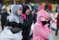 Runners cover themselves from the low temperatures and strong wind before the start of the New York City Marathon in New York, November 2, 2014. . REUTERS/Eduardo Munoz (UNITED STATES - Tags: SPORT ATHLETICS)