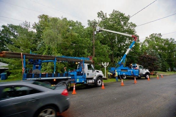 Crews from Consumers Energy work to fix downed power lines.