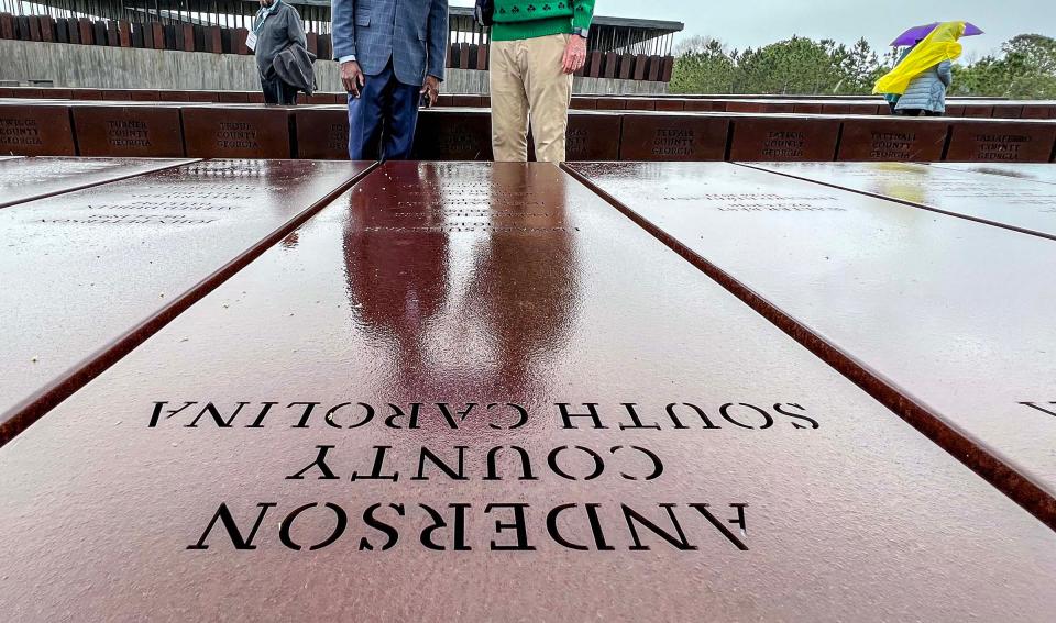 Terence Roberts, left, Mayor of Anderson, and John Miller, Jr., right, both with the Anderson Area Remembrance & Reconciliation Initiative visit a marker for Anderson County, South Carolina at the National Memorial for Peace and Justice in Montgomery, Alabama March 17, 2023. Names on the metal sculpture are Ed Sullivan, of Williamston town area 1894, Elbert Harris of Iva in 1898, John Laddison of Rock Milll area in 1901, Reuben Elrod of Brushy Creek in 1903, and Willis Jackson of Honea Path in 1911. The group later group leader, presented Jennifer Harris, Senior Project Manager at the Equal Justice Initiative office, five jars of collected soil collected from Anderson County, S.C. lynching sites of the men listed. 