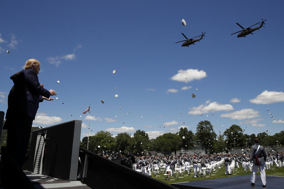 President Donald Trump applauds as Army helicopters fly over and West Point cadets toss their caps into the air at the end of commencement ceremonies on the parade field, at the United States Military Academy in West Point, N.Y., Saturday, June 13, 2020. (AP Photo/Alex Brandon)