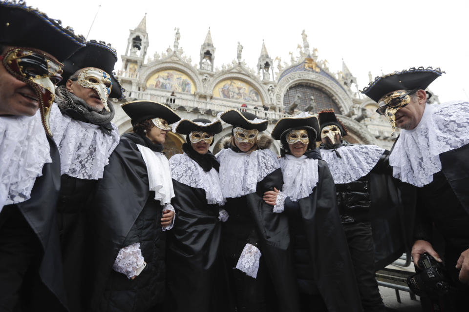 FILE - In this Feb.11, 2017 file photo, men wears masks, some of them pest doctor masks, in St. Mark's Square in Venice, Italy. This carnival mask derives from 16th century doctors wearing beak-nosed masks filled with aromatic herbs to cleanse the air they breathed when treating the sick. Venice’s central place in the history of battling pandemics and pestilence will come into focus at this year’s Venice Film Festival, which opens Wednesday, Sept. 1, 2021, with the premiere of Pedro Almodovar’s in-competition “Madres Paralelas” (Parallel Mothers), which he developed during Spain’s 2020 coronavirus lockdown, one of the harshest in the West. (AP Photo/Luca Bruno)