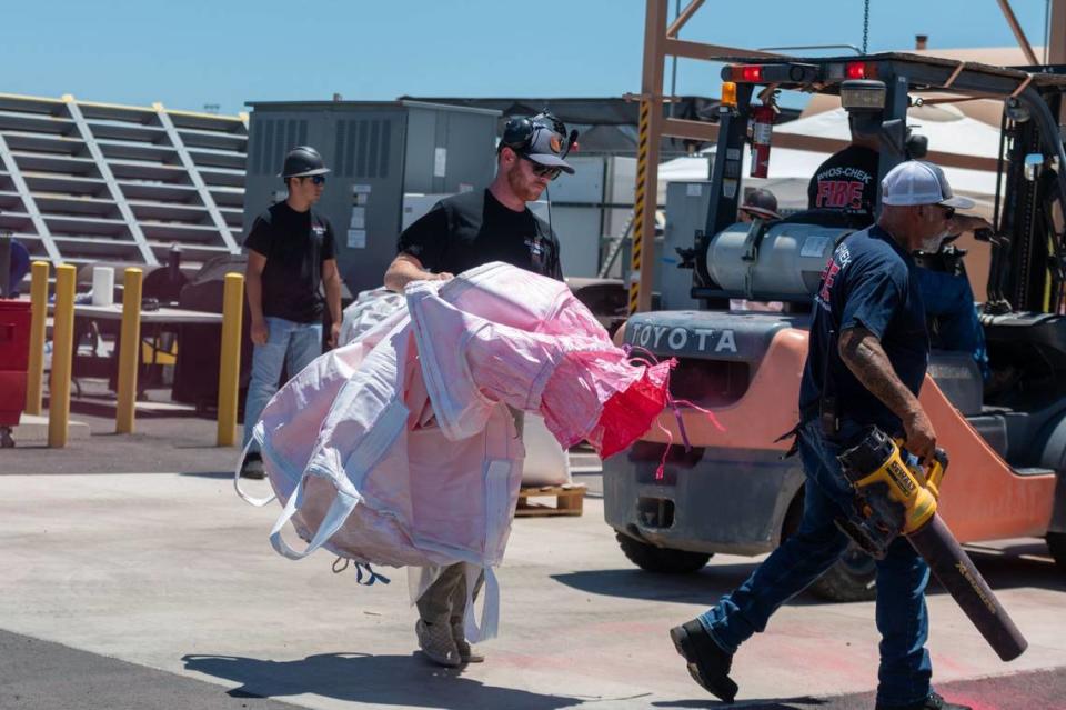 Phos-Chek employee discards empty bag of pink ammonium phosphate at Cal Fire McClellan Reload Base in McClellan on June 25. Fire retardant is made of 12% ammonium phosphate and 88% water.