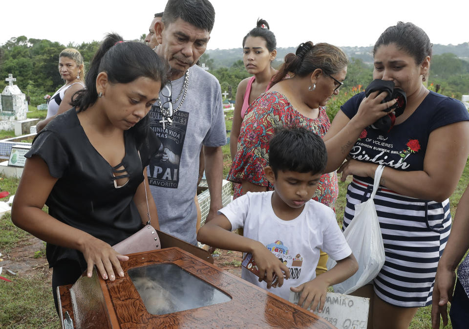 Relatives stand next to the coffin that contain the remains of 25-year-old William de Souza, an inmate who was killed in the recent prison riots, during his burial service, in Manaus, Brazil, Thursday, May 30, 2019. Families were burying victims of several prison riots in which dozens of inmates died in the northern Brazilian state of Amazonas, as authorities confirmed they had received warnings of an “imminent confrontation” days before the attacks begun. (AP Photo/Andre Penner)