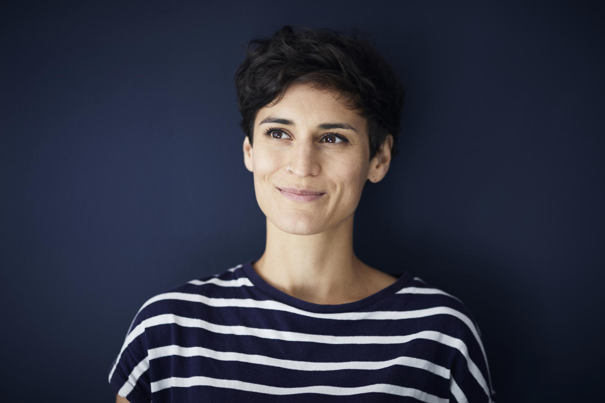 Portrait of smiling woman at blue wall