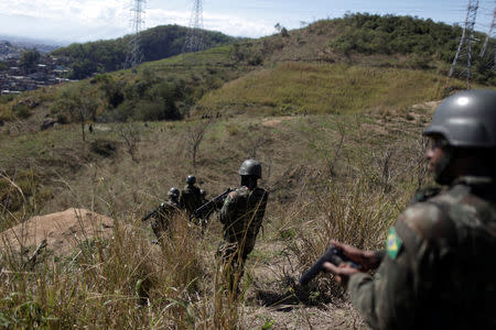 Brazilian Army soldiers patrol during an operation against drug gangs in Alemao slums complex in Rio de Janeiro, Brazil August 20, 2018. REUTERS/Ricardo Moraes