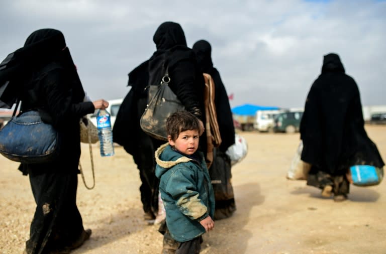 A boy with women fleeing the northern embattled city of Aleppo wait near the Turkish border crossing on February 6, 2016