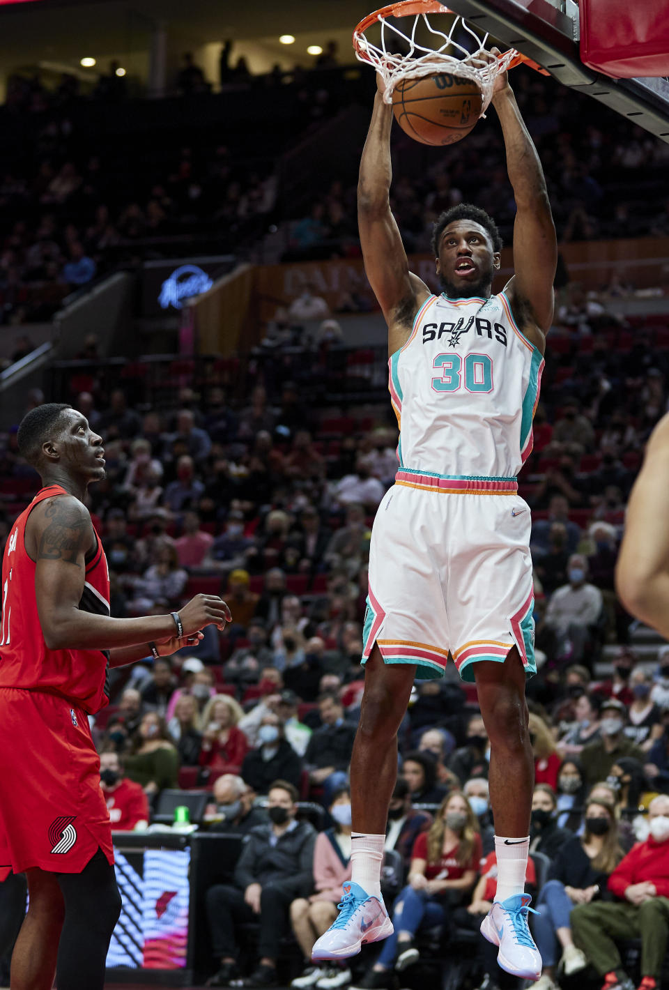 San Antonio Spurs forward Thaddeus Young, right, dunks in front of Portland Trail Blazers forward Tony Snell during the first half of an NBA basketball game in Portland, Ore., Thursday, Dec. 2, 2021. (AP Photo/Craig Mitchelldyer)