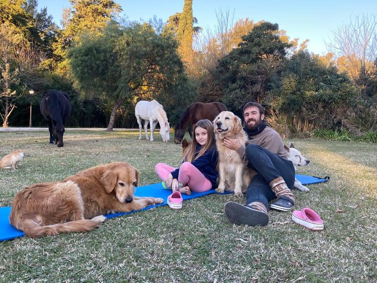 Oscar Ahumada, en su remanso, junto a una de sus hijas, Sofía, sus mascotas y los caballos en su campo en las afueras de Zárate