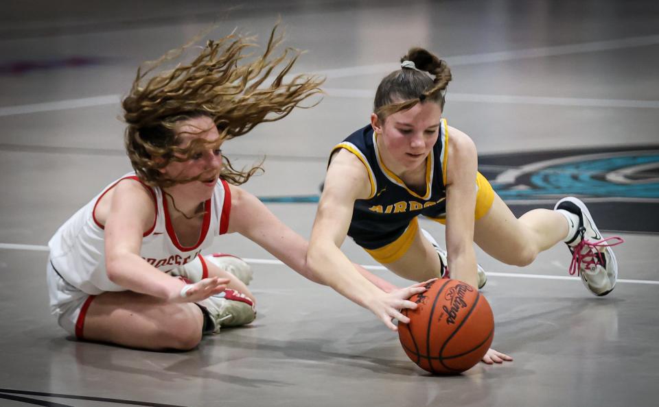 Brenna Baker of Airport (right) Grosse Ile's Kylee Wright dive for a loose ball during Airport's 64-46 victory in the finals of the Division 2 District at Summit Academy on Friday, March 8, 2024.