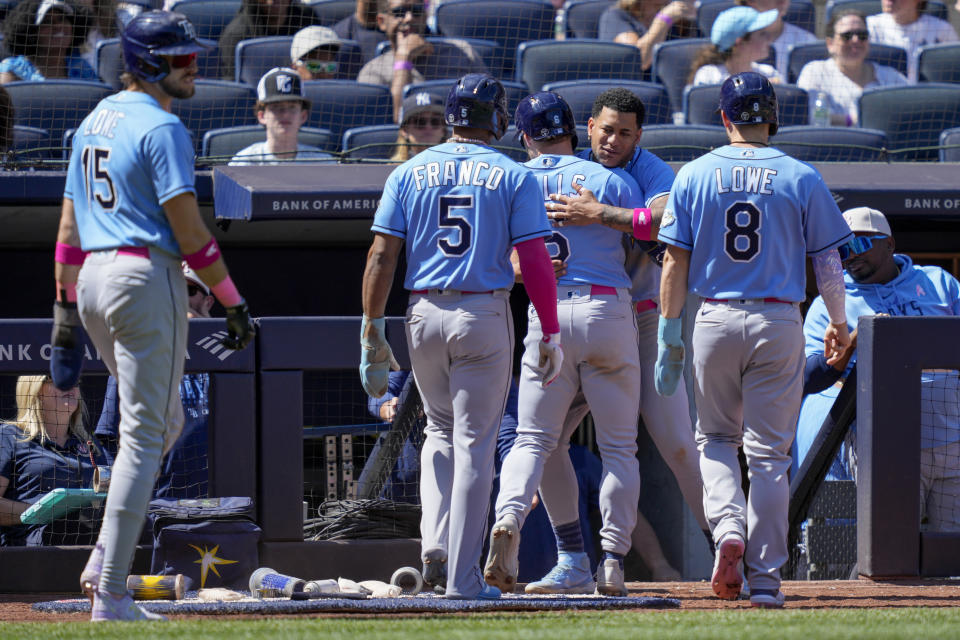 Tampa Bay Rays' Taylor Walls, center right, celebrates with his teammates after hitting a grand slam off New York Yankees relief pitcher Albert Abreu (84) in the fifth inning of a baseball game, Sunday, May 14, 2023, in New York. (AP Photo/John Minchillo)